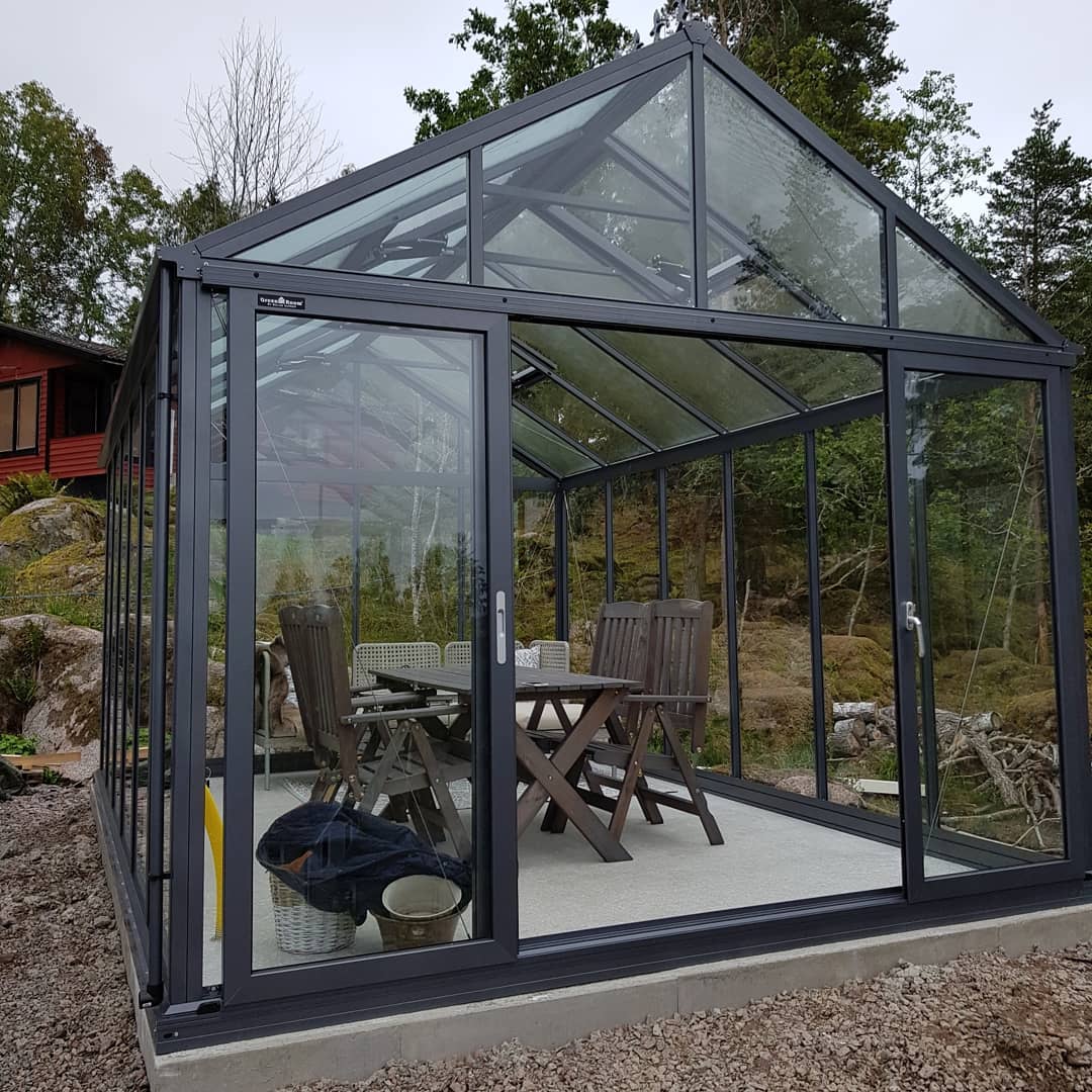 Glasat uterum med svart aluminiumstomme och möblerad sittgrupp – altanbygge och tillbyggnad i Norrköping